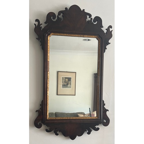 1098 - A mahogany and gilt fretted wall mirror. 78cm x 46cm.