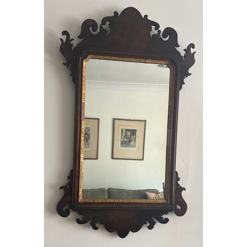 1098 - A mahogany and gilt fretted wall mirror. 78cm x 46cm.