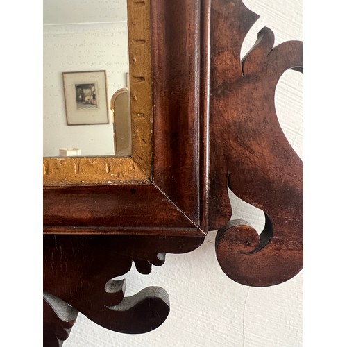 1098 - A mahogany and gilt fretted wall mirror. 78cm x 46cm.