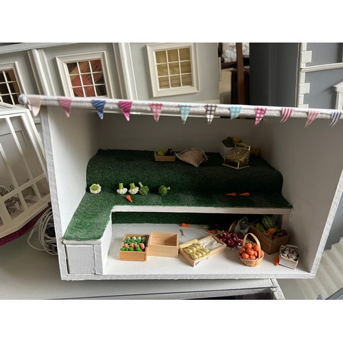 1113 - A modern dolls house, 61cm w x 83cm h x 31cm w together with bakers shop, music room, shop with acco... 