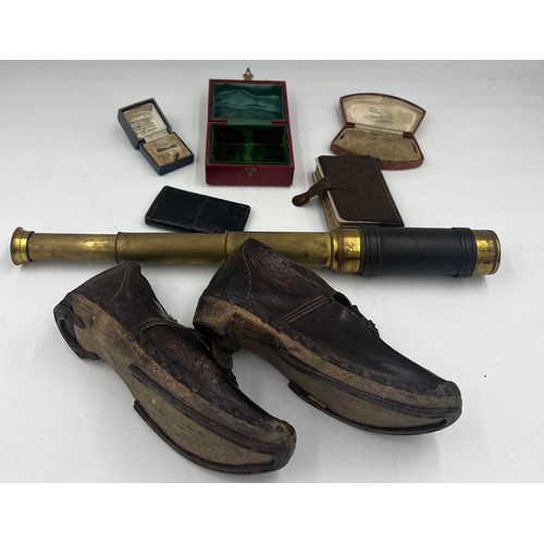 1360 - A miscellany to include a pair of 19thC child’s leather and wooden clogs, a brass and leather covere... 