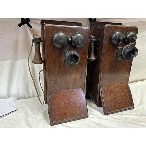 1281 - Two wooden cased wall mounted telephones, with mouth piece to the left hand side, crank handle to th... 