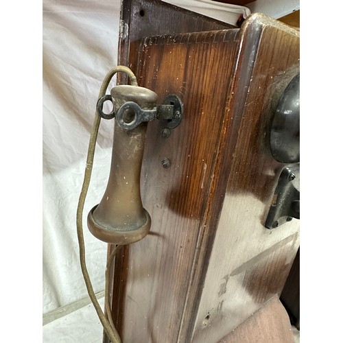 1281 - Two wooden cased wall mounted telephones, with mouth piece to the left hand side, crank handle to th... 