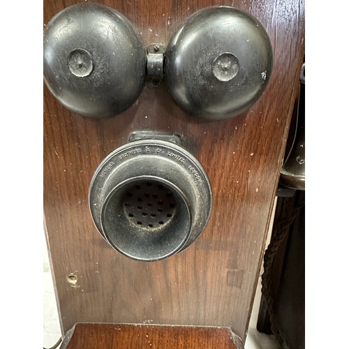 1281 - Two wooden cased wall mounted telephones, with mouth piece to the left hand side, crank handle to th... 