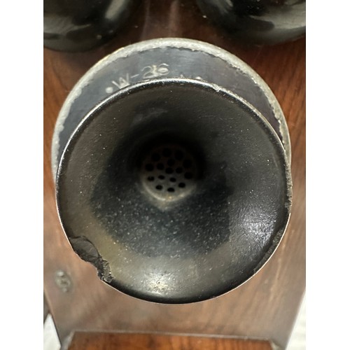 1281 - Two wooden cased wall mounted telephones, with mouth piece to the left hand side, crank handle to th... 