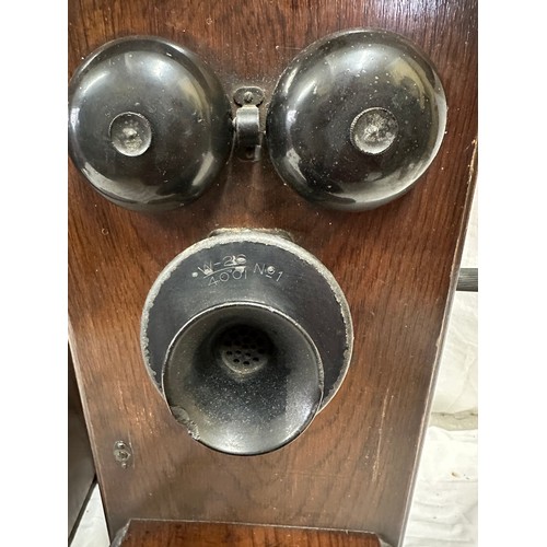 1281 - Two wooden cased wall mounted telephones, with mouth piece to the left hand side, crank handle to th... 