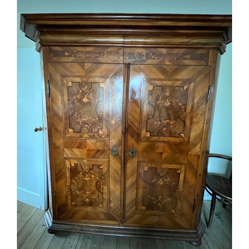 126 - An 18thC Austrian inlaid two door wardrobe on bun feet. Dated 1727 to the top. 202cm h x 57cm d x 17... 