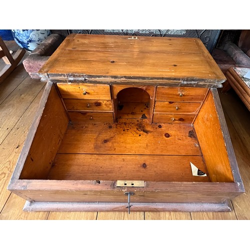 129 - A pine table top desk with sloping lid and fitted interior. 63cm x 49cm x 26cm h.