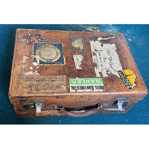 1246 - A vintage leather suitcase with luggage labels. 56cm x 38cm x 21cm.