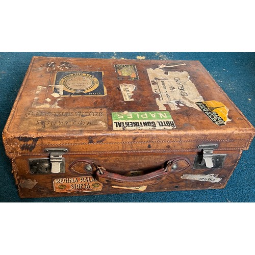 1246 - A vintage leather suitcase with luggage labels. 56cm x 38cm x 21cm.