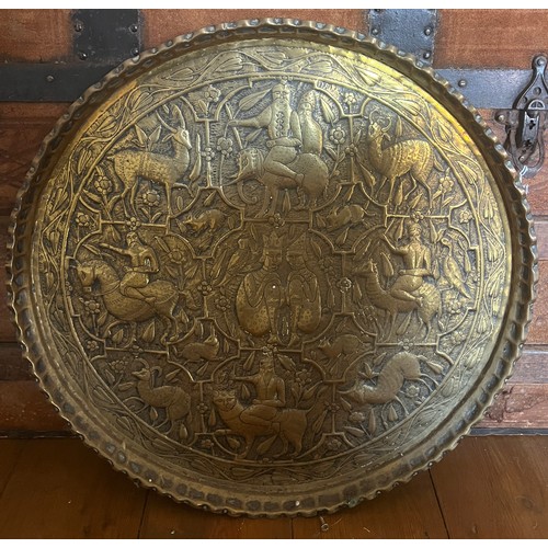 932 - An embossed circular brass tray. 45cm d.