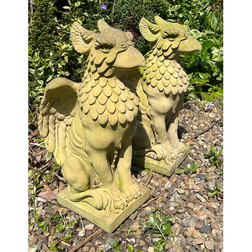 5 - A pair of reconstituted stone griffins. 57cm h.