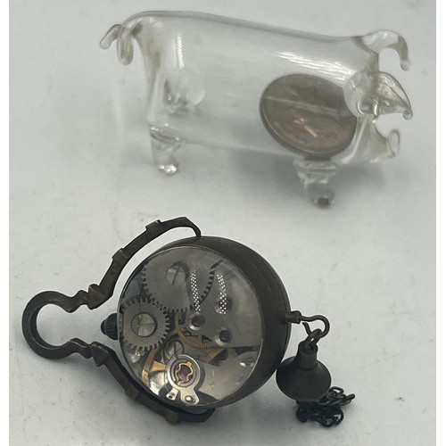 726 - An Omega glass ball clock together with a glass pig with five pence to interior.