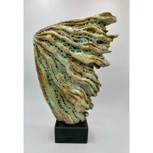 334 - Wendy Lawrence; a carved stoneware sculpture layered with textured volcanic glazes on a stone base, ... 