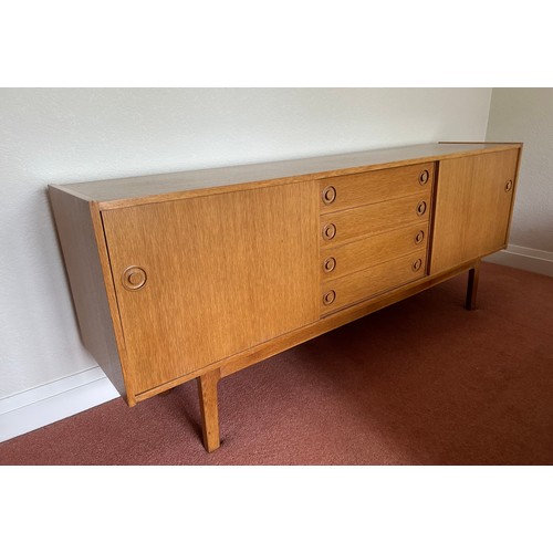 111 - A Mid Century Scandinavian style sideboard with four central drawers, the top one fitted with three ... 