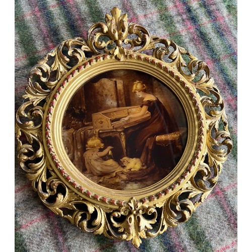 1365 - A 19thC crystoleum depicting a mother at the piano with a child and cat at play in a decorative gilt... 