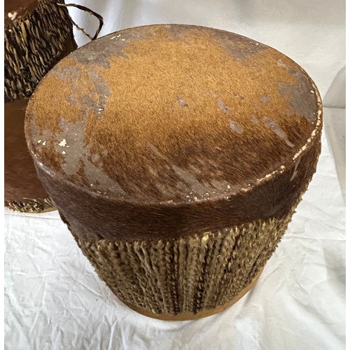 981 - Two traditional African cow hide drums. Tallest 42cm x 26cm, other 36cmx31cm. Rush decoration to edg... 