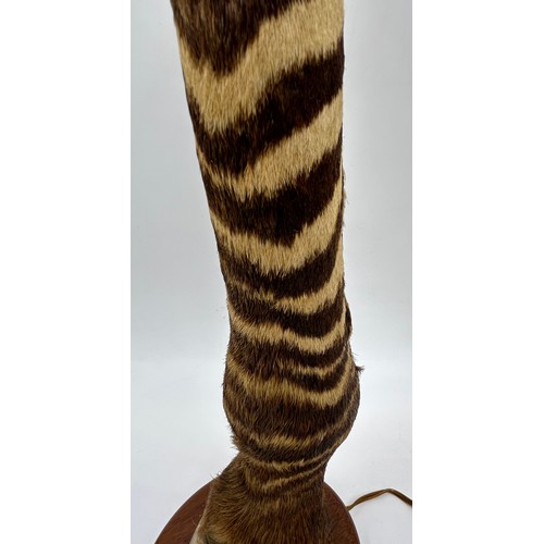 1019 - A taxidermy table lamp formed from a zebra leg on a wooden base together with a carved wooden lion t... 