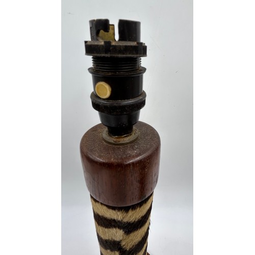 1019 - A taxidermy table lamp formed from a zebra leg on a wooden base together with a carved wooden lion t... 