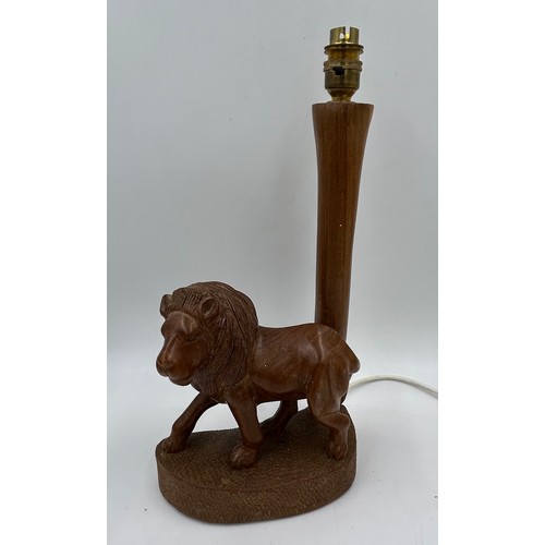 1019 - A taxidermy table lamp formed from a zebra leg on a wooden base together with a carved wooden lion t... 