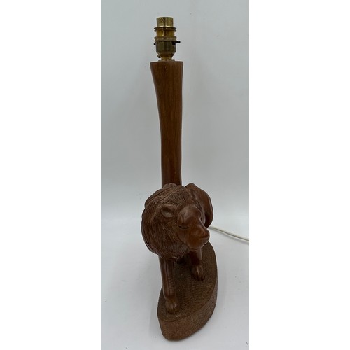 1019 - A taxidermy table lamp formed from a zebra leg on a wooden base together with a carved wooden lion t... 