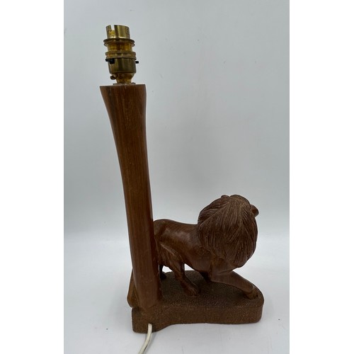 1019 - A taxidermy table lamp formed from a zebra leg on a wooden base together with a carved wooden lion t... 