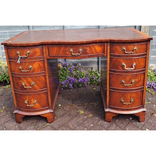 102 - A mahogany kneehole desk with serpentine front and tooled leather top. 115cm w x 53cm d x 75cm h.