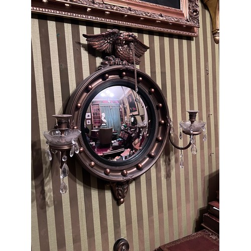 1238 - A circular convex wall mirror with eagle top and later additions. 59cm w x 66cm h.