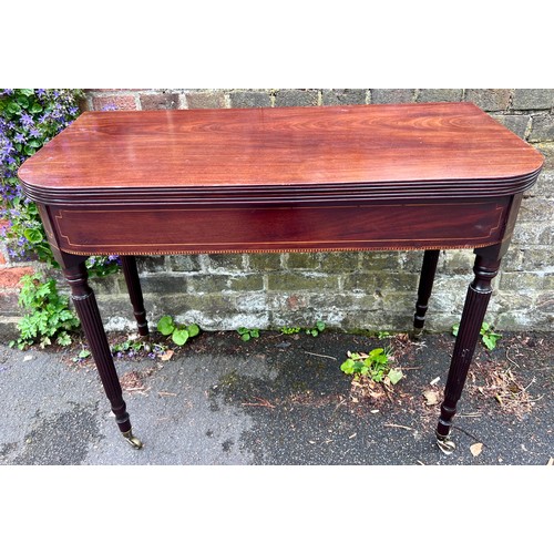 70 - A Gillows mahogany fold over tea table on reeded legs with brass castors. 91cm w x 45cm d x 75cm h. ... 