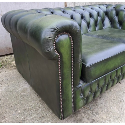 64 - A green leather two seater sofa, 70cm h x 158cm w x 90cm d.