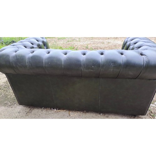 64 - A green leather two seater sofa, 70cm h x 158cm w x 90cm d.