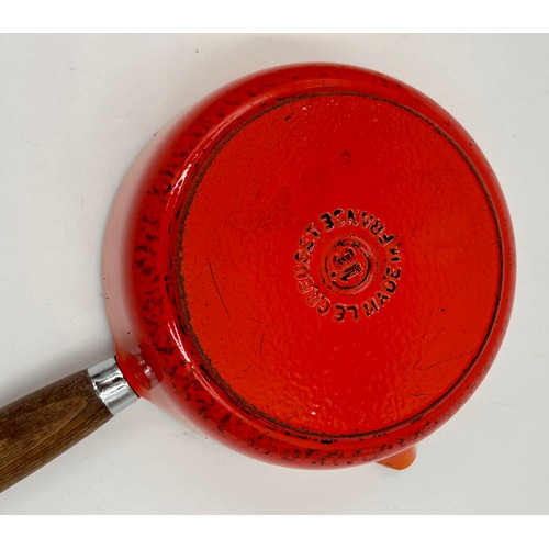 955 - A quantity of Le Creuset volcanic orange to include : three lidded enamelled pans, 22cm, 18cm and 16... 