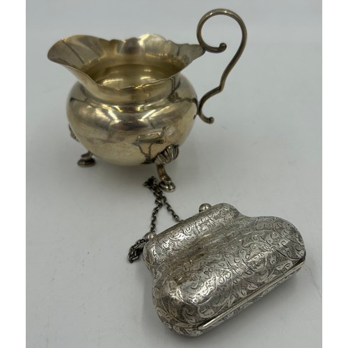 812 - Hallmarked silver purse George Unite London 1889 and a jug raised on three feet Birmingham 1915, mak... 