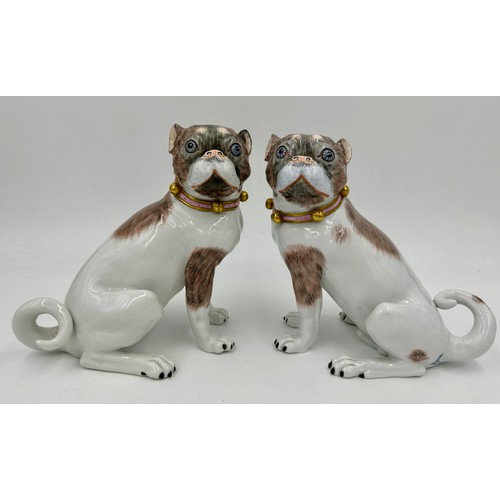 227 - A pair of Dresden pug dogs, pink collars with gold bells, printed marks in blue to base and serial n... 