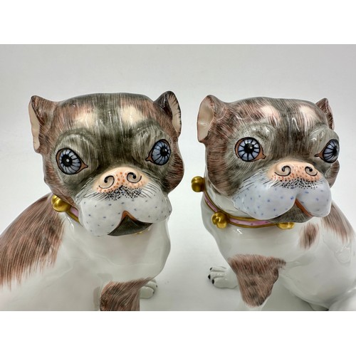 227 - A pair of Dresden pug dogs, pink collars with gold bells, printed marks in blue to base and serial n... 