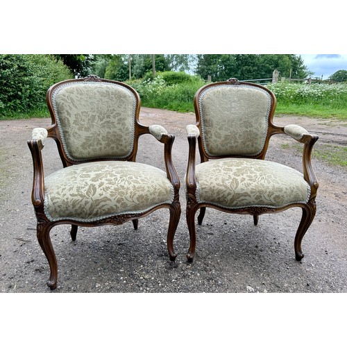 65 - Two upholstered open armchairs/fauteuils in the French style with cabriole legs to front and floral ... 