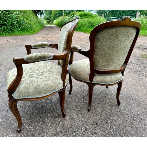 65 - Two upholstered open armchairs/fauteuils in the French style with cabriole legs to front and floral ... 