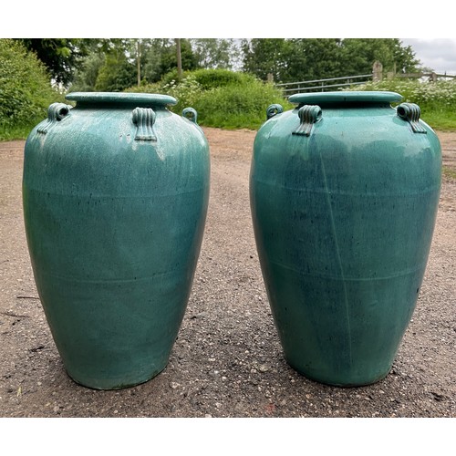 19 - A pair of ceramic turquoise garden urns. 69cm h.