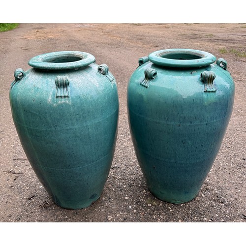 19 - A pair of ceramic turquoise garden urns. 69cm h.