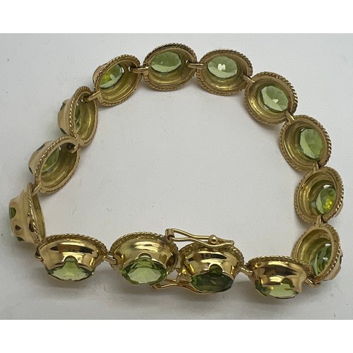 691 - A 18 carat gold bracelet with peridots. Weight 25.3gm.