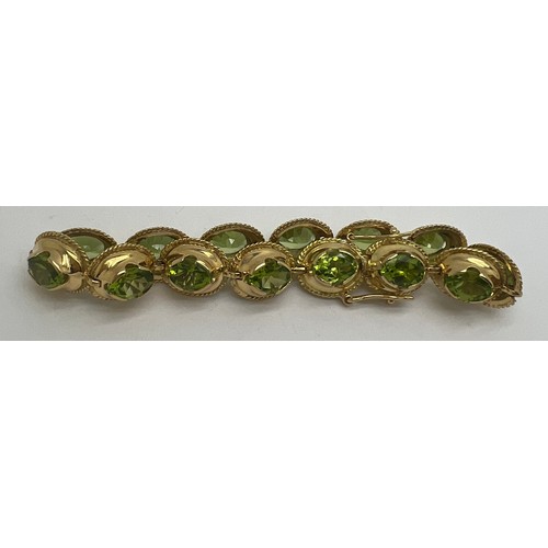 691 - A 18 carat gold bracelet with peridots. Weight 25.3gm.