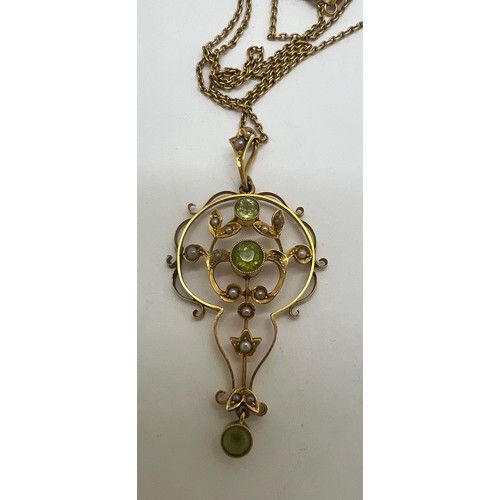 692 - A 15 carat gold pendant set with seed pearls and peridots. Chain 37cm l.