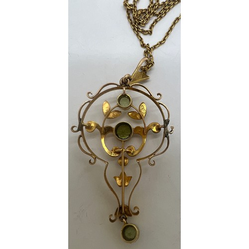 692 - A 15 carat gold pendant set with seed pearls and peridots. Chain 37cm l.