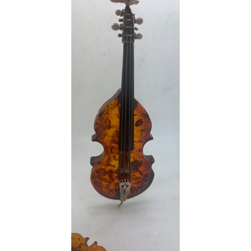 756 - Amber and .925 silver violin and cello with a .925 silver and amber paper knife, 13.5cm l.