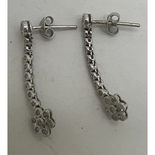 684 - A pair of 18 carat white gold and diamond drop earrings. Weight 2.5gm. Length 2.5cm.