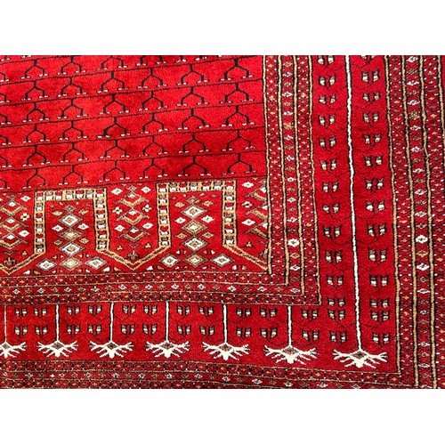 1221 - A large red Kashmir wool carpet. Approx. 179 x 280cm.