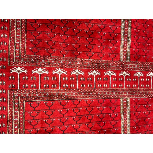 1221 - A large red Kashmir wool carpet. Approx. 179 x 280cm.