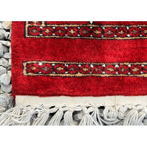 1221 - A large red Kashmir wool carpet. Approx. 179 x 280cm.