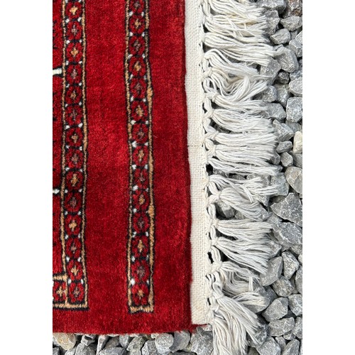 1221 - A large red Kashmir wool carpet. Approx. 179 x 280cm.