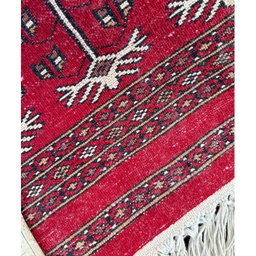 1221 - A large red Kashmir wool carpet. Approx. 179 x 280cm.